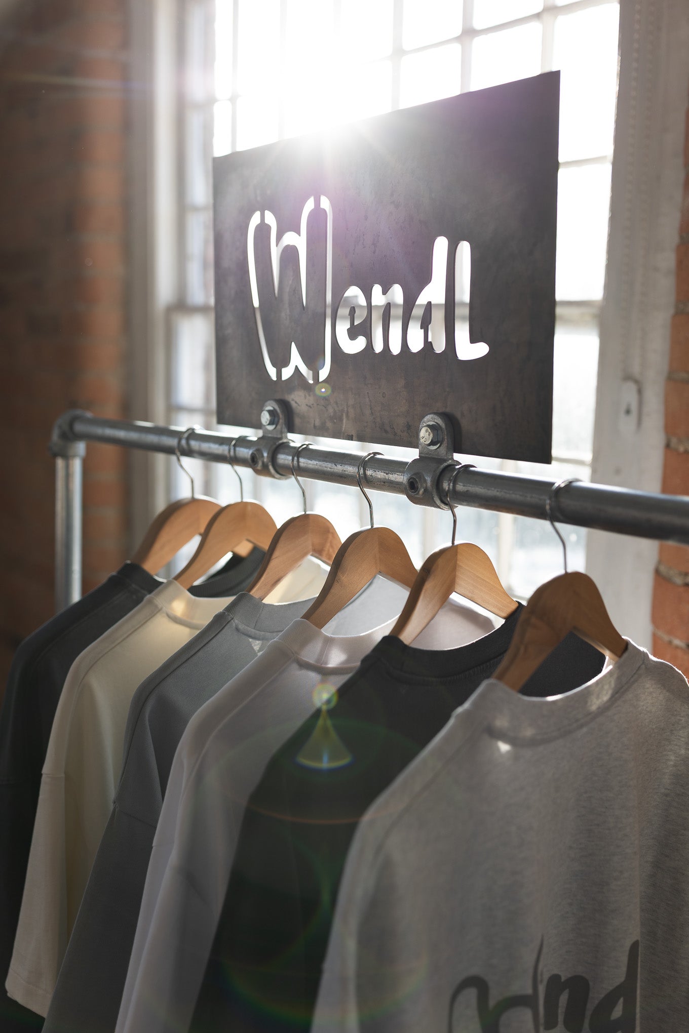 Row of shirts on hangers with a 'Wendl' sign in the background